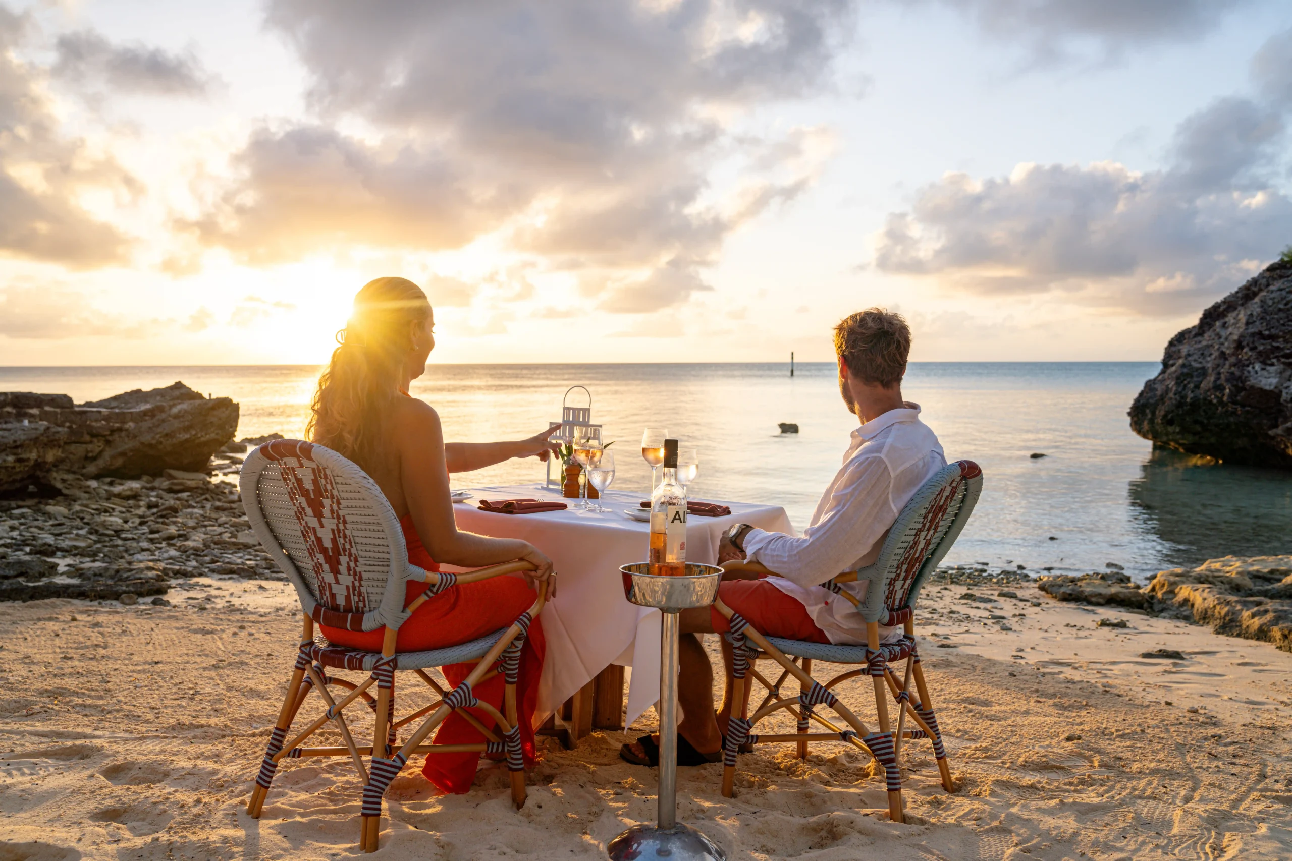 Couple enjoying meal with a sunset on a beach in Bermuda